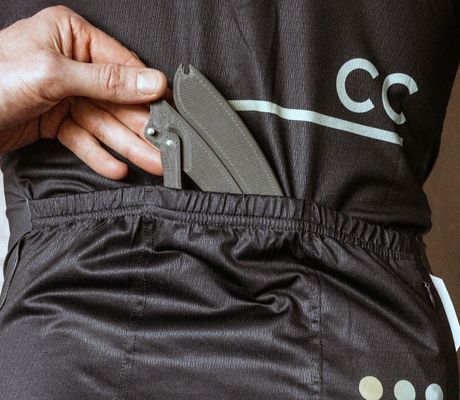 yclist sliding the PLAced Tirer tyre lever into a rear jersey pocket—compact and ride-ready.