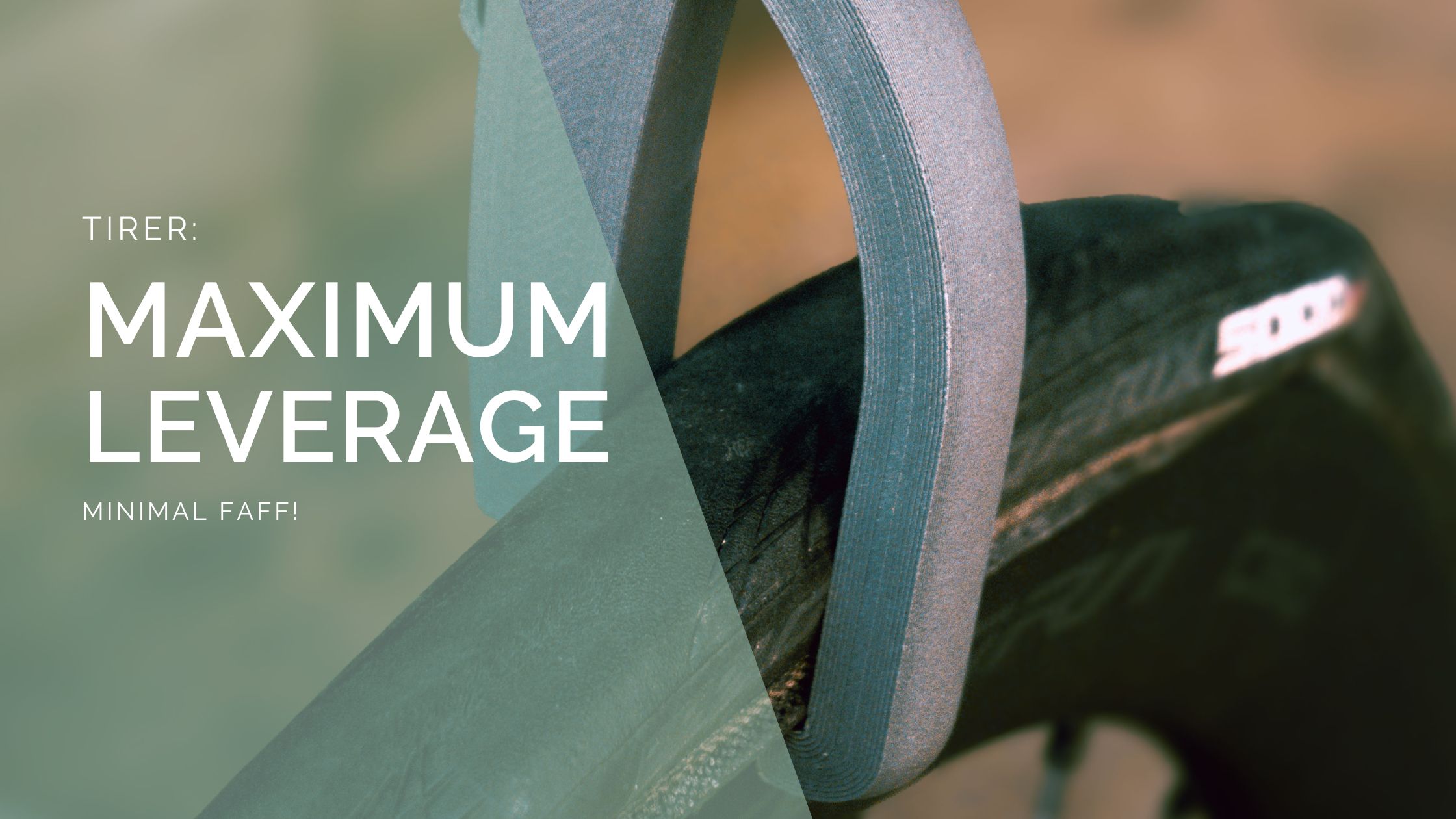 Close-up of the PLAced Tirer tyre lever in use on a road bike, with text overlay reading ‘Maximum Leverage, Minimal Faff!’